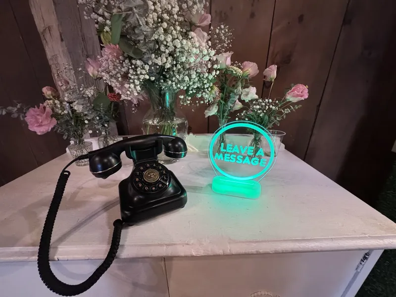 The Audio Guest Book at a Maple Meadows wedding: vintage phone and a glowing Leave a Message sign