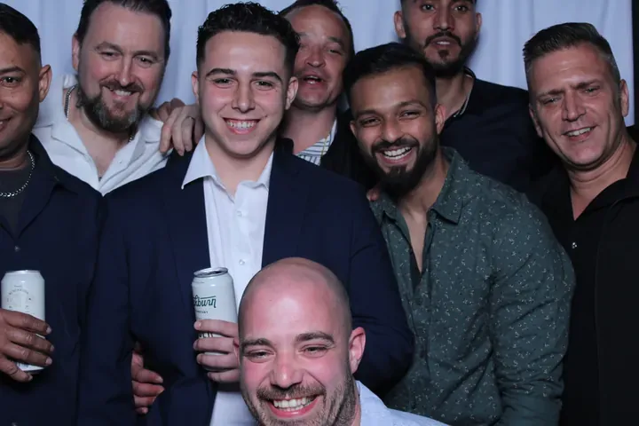 Group of men laughing in the photo booth at a Niagara Falls wedding