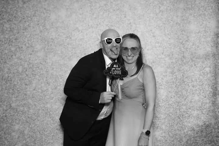Couple with an All You Need Is Love sign at a Niagara-on-the-Lake wedding photo booth