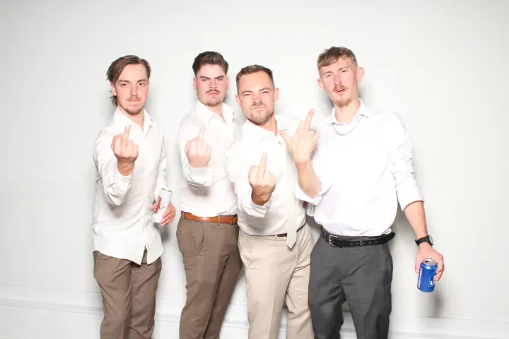 Four men pointing at the camera in a wedding photo booth