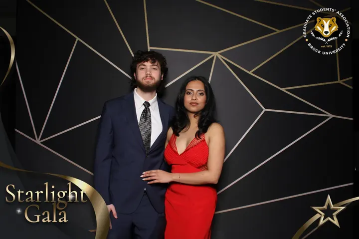 Couple in a navy suit and red dress at a St. Catharines gala photo booth