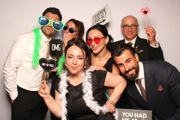 Six wedding guests with OMG and We Love You signs at the photo booth