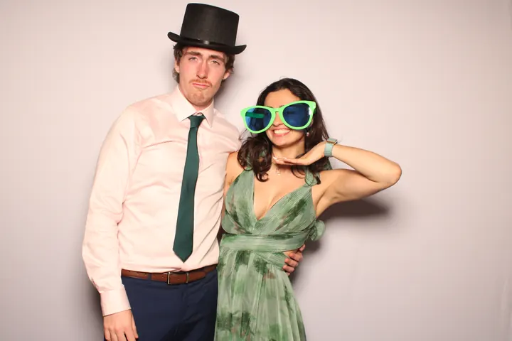 Wedding guests in a top hat and giant green sunglasses at the photo booth
